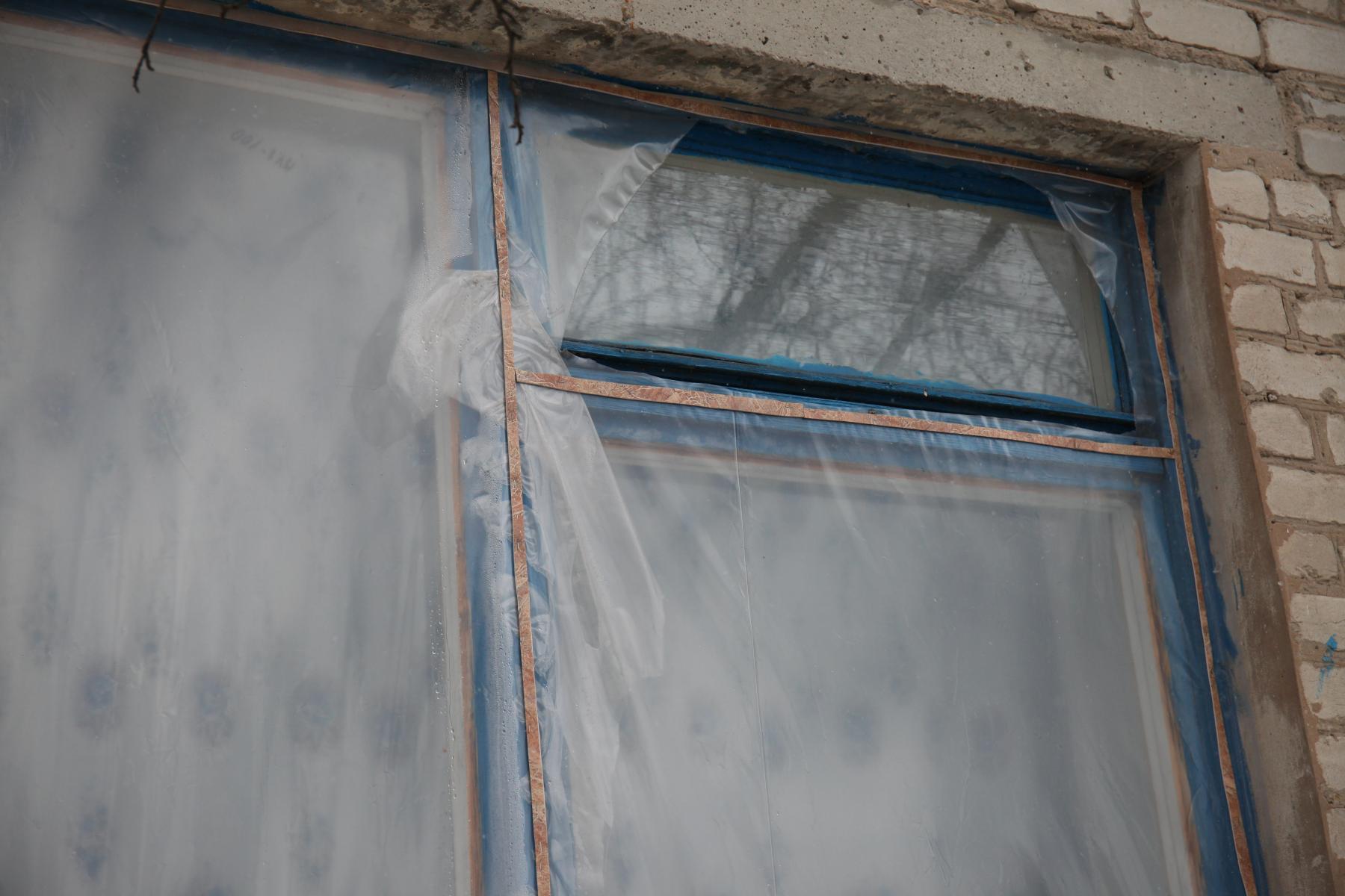 Затянутые пленкой окна, которые пока не нашлось возможности застеклить после обстрелов 