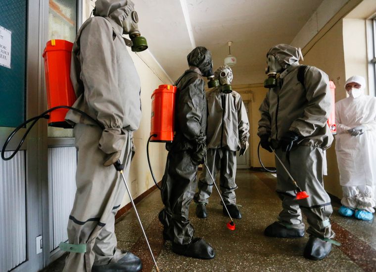 Працівники екстреної служби «ДНР» готуються розпорошувати дезінфікуючий засіб в лікарні, де лікуються хворі COVID-19 / Фото: EPA/DAVE MUSTAINE